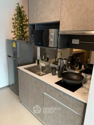 Modern compact kitchen with sleek appliances and festive decor