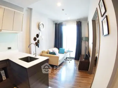 Modern living room with open kitchen, stylish decor, and natural light.