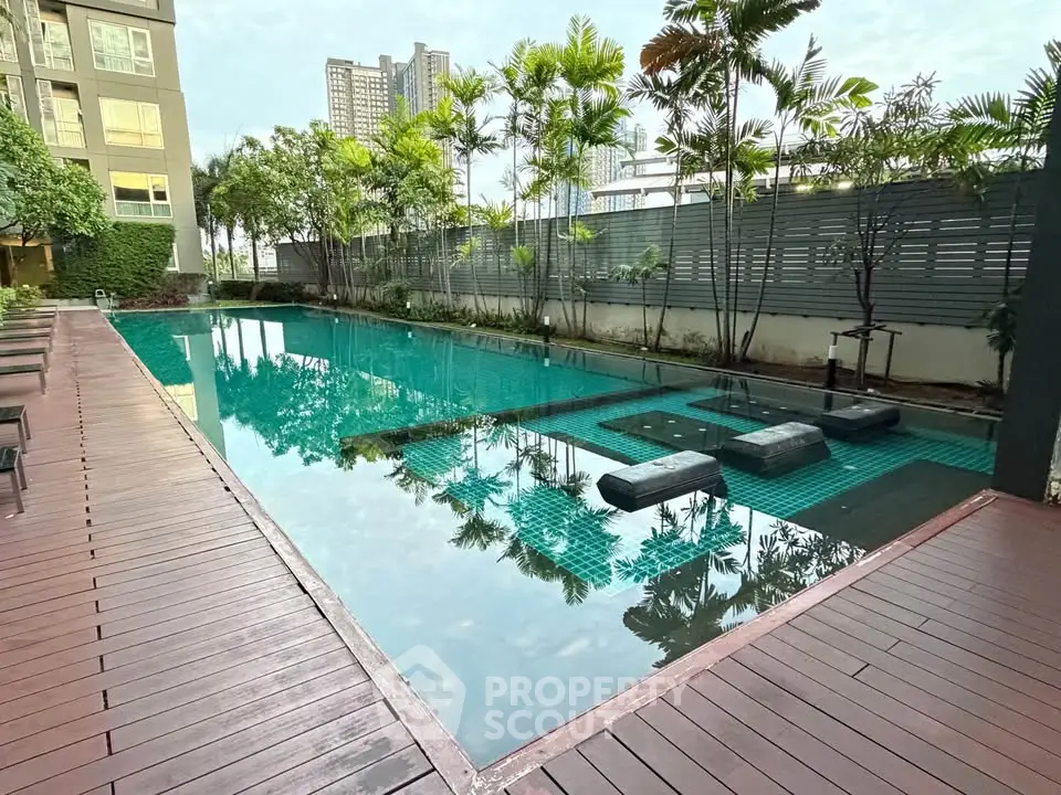 Luxurious condominium pool area with modern design and lush greenery, perfect for relaxation and leisure.