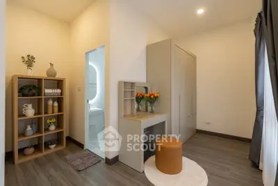 Charming bedroom with elegant decor and natural light, featuring a cozy vanity area and stylish storage solutions.
