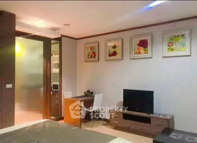 Cozy bedroom with modern decor and wall art, featuring a small desk and TV unit for comfortable living.