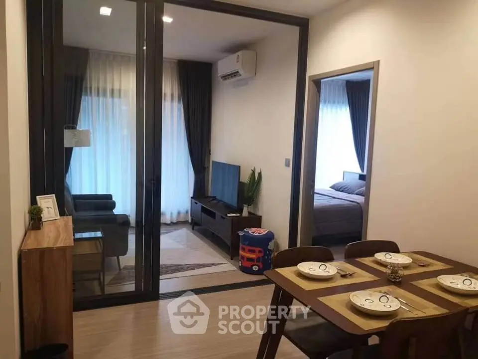 Modern apartment interior with open living and dining area, featuring stylish furniture and natural light.