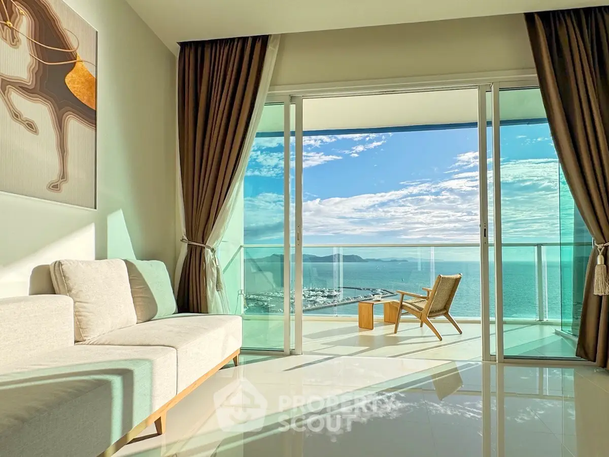 Luxurious living room with stunning ocean view and elegant balcony seating.