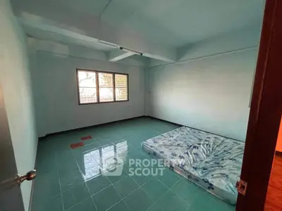 Spacious unfurnished bedroom with tiled floor and large window, perfect for customization.