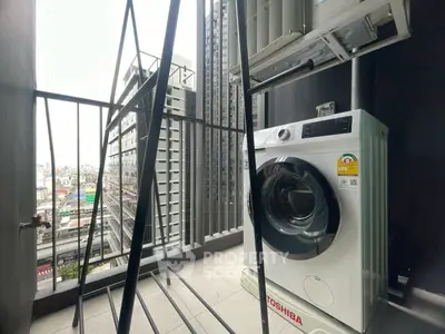 Modern balcony with city view and washing machine in high-rise apartment