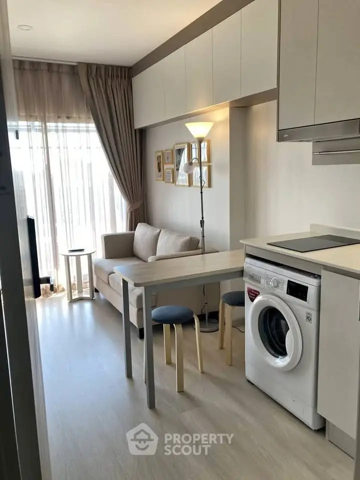 Modern studio apartment with washing machine and cozy living area, perfect for urban living.