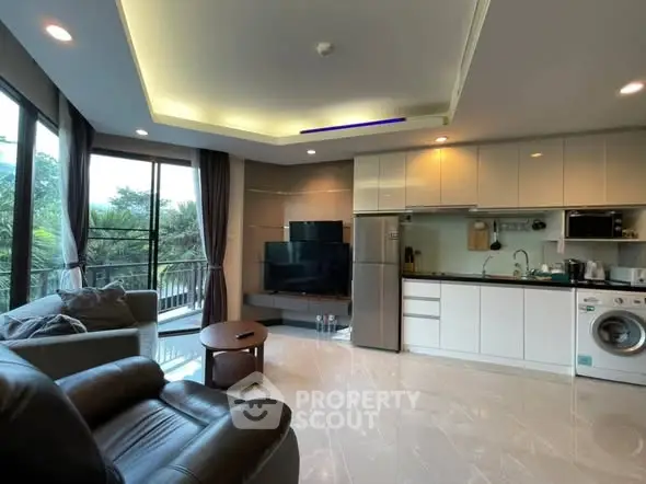 Modern living room with open kitchen, large windows, and scenic view.