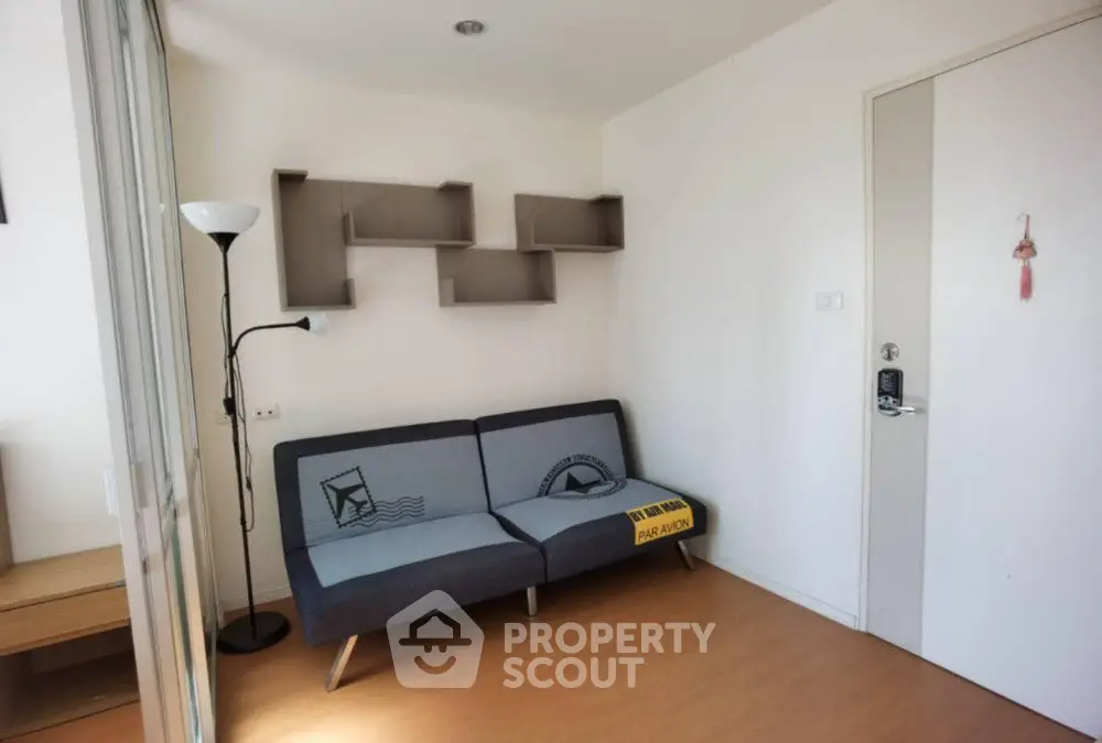 Cozy living room with modern sofa and wall-mounted shelves in a bright apartment.