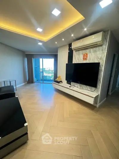 Modern living room with sleek design, large TV, and balcony access in a stylish apartment.