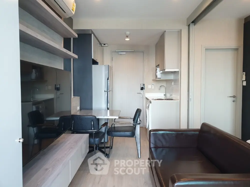Modern open-layout living room with sleek furniture and integrated kitchen area.