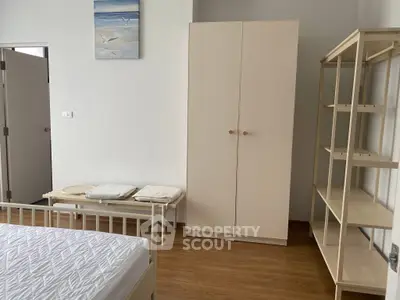 Spacious bedroom with minimalist furniture and wooden flooring