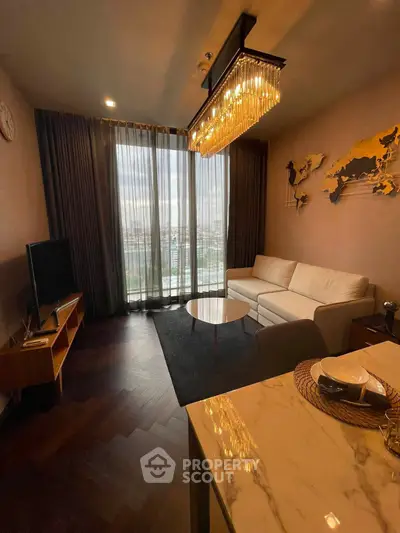 Luxurious living room with elegant chandelier and stunning city view from floor-to-ceiling windows.