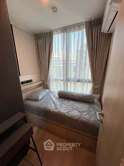 Cozy bedroom with modern design and large window for natural light.