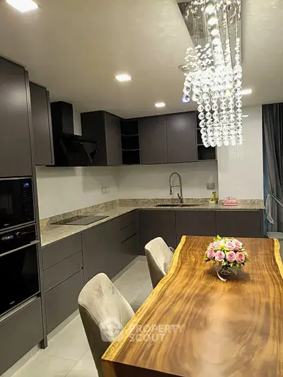 Luxurious modern kitchen with sleek cabinetry and elegant chandelier lighting