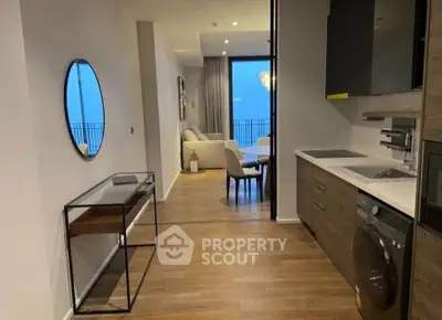 Modern apartment interior with open kitchen and living area, featuring sleek design and balcony view.