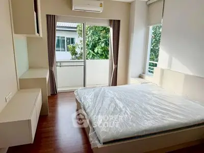 Bright bedroom with large window and balcony access in modern apartment