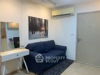 Cozy living room with blue sofa, wall art, and air conditioning in modern apartment.