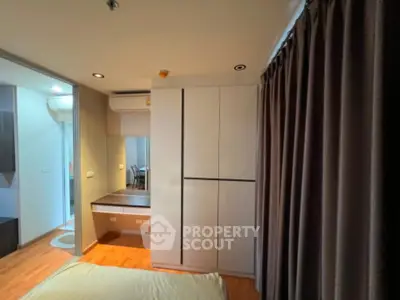 Modern bedroom with sleek wardrobe and cozy lighting in a stylish apartment.
