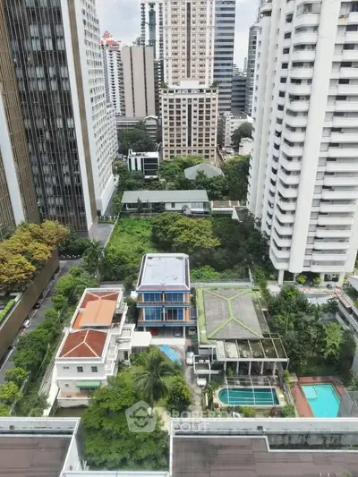 Stunning aerial view of urban high-rise buildings with lush greenery and swimming pools in a vibrant cityscape.