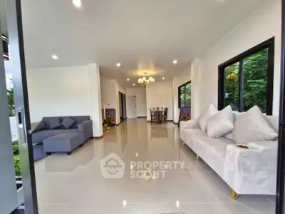 Spacious modern living room with elegant sofas and dining area, featuring large windows and glossy tiled floors.