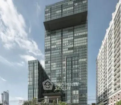 Modern high-rise building with sleek glass facade and urban surroundings.