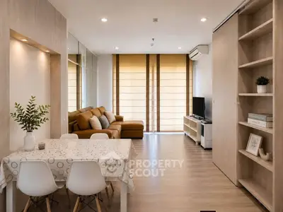 Modern living room with stylish decor and open layout, featuring a cozy sofa and dining area.
