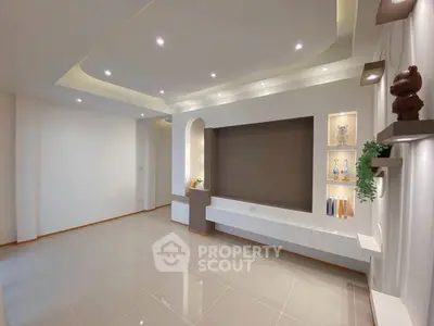 Spacious modern living room with elegant recessed lighting and sleek built-in shelves.