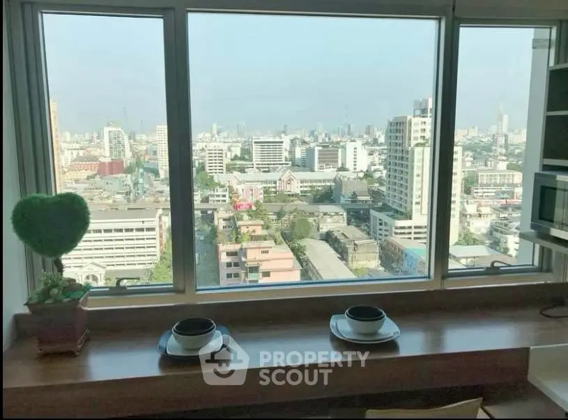 Stunning city view from a modern apartment window with cozy breakfast nook.