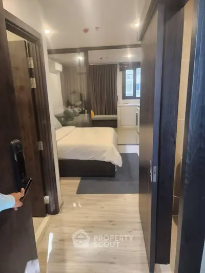 Modern bedroom with cozy bed, stylish decor, and natural light, perfect for urban living.