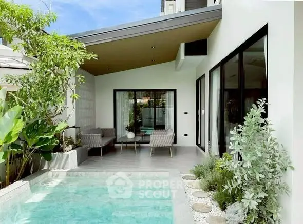 Luxurious modern home with private pool and stylish outdoor seating area, perfect for relaxation and entertainment.