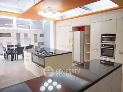 Modern kitchen with island, gas stove, and dining area in open layout