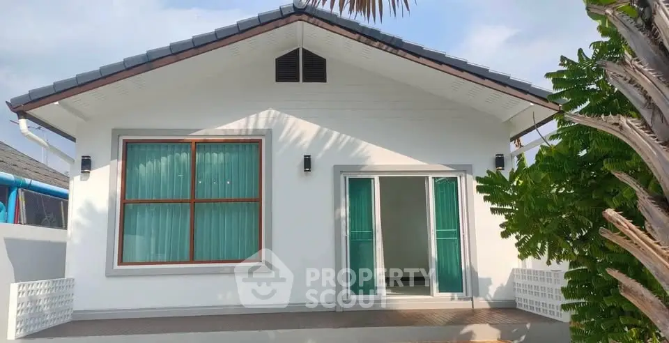 Charming single-story house with modern design and lush greenery, perfect for serene living.