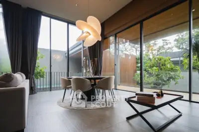Modern living room with elegant dining area and large windows overlooking lush greenery.