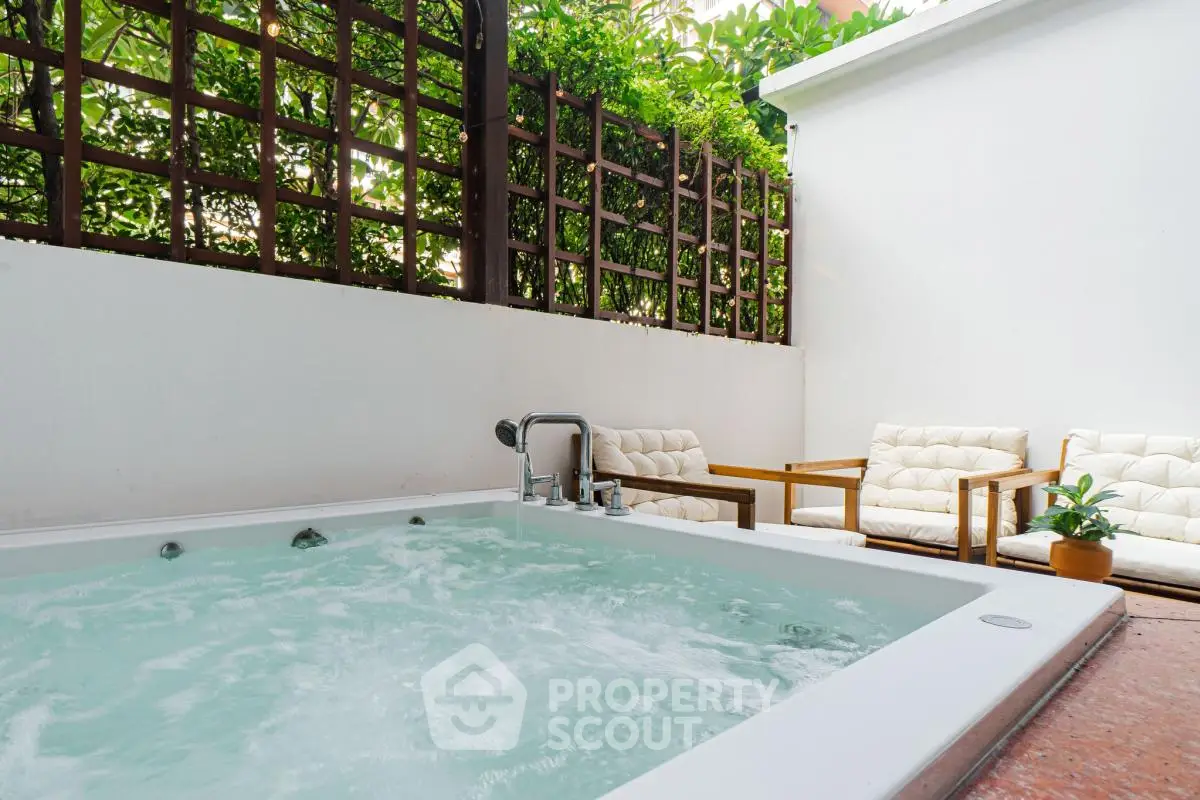Luxurious outdoor jacuzzi with cozy seating area and lush greenery