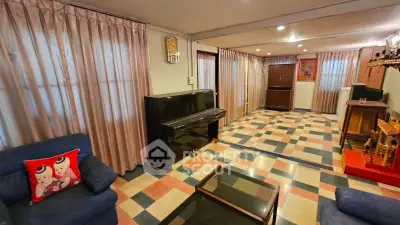 Spacious living room with piano and colorful tiled flooring, perfect for entertainment and relaxation.