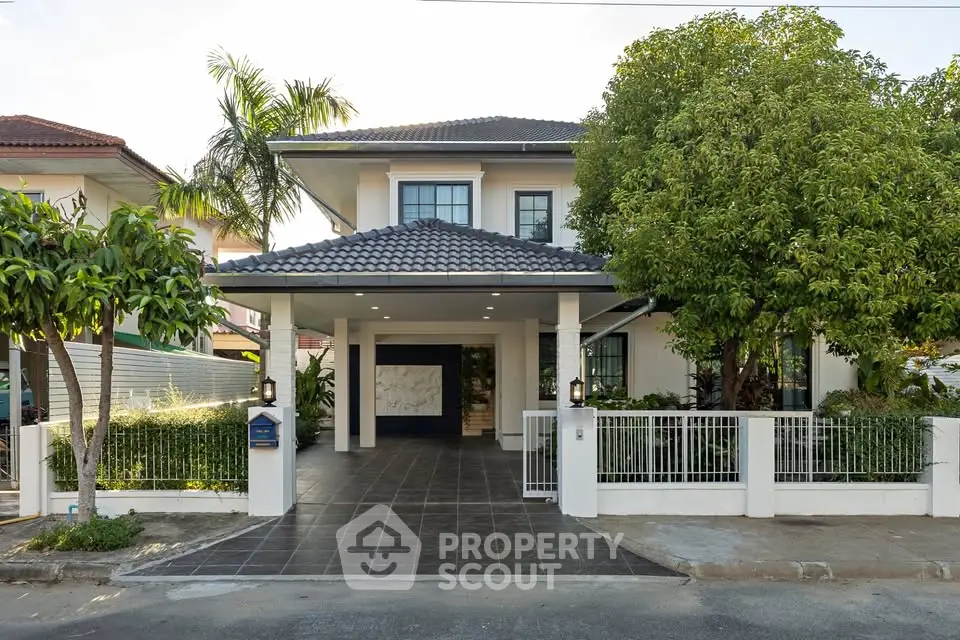 Charming two-story house with lush garden and spacious driveway in a serene neighborhood.