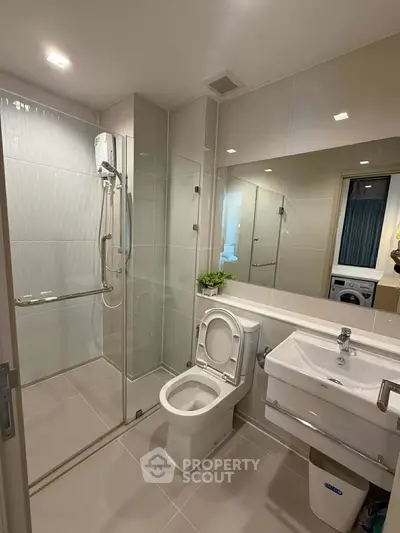 Modern bathroom with glass shower and sleek fixtures in a contemporary apartment.
