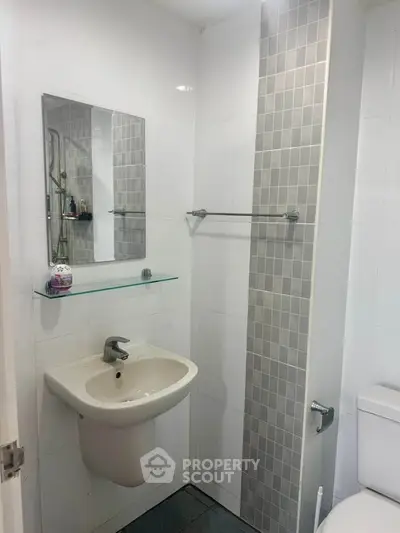 Modern bathroom with sleek sink and tiled wall accent