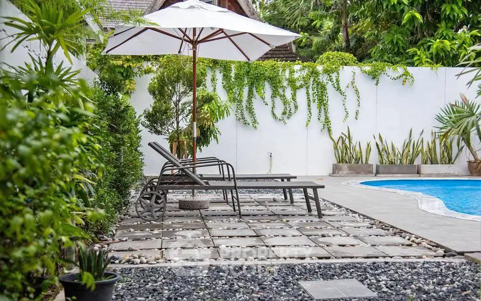 Luxurious outdoor pool area with stylish loungers and lush greenery, perfect for relaxation and entertaining.