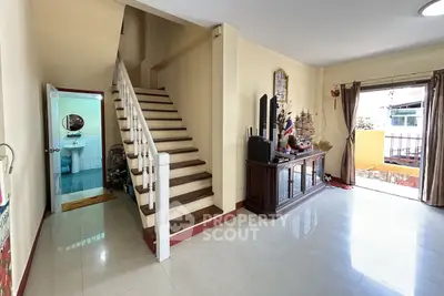 Spacious living room with staircase and balcony access in a modern home