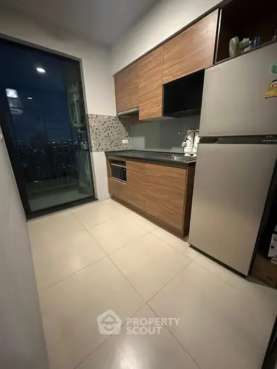Modern kitchen with sleek cabinets and stainless steel fridge, offering a stylish and functional cooking space.