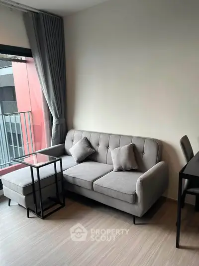 Modern living room with stylish gray sofa and sleek furniture in a contemporary apartment.