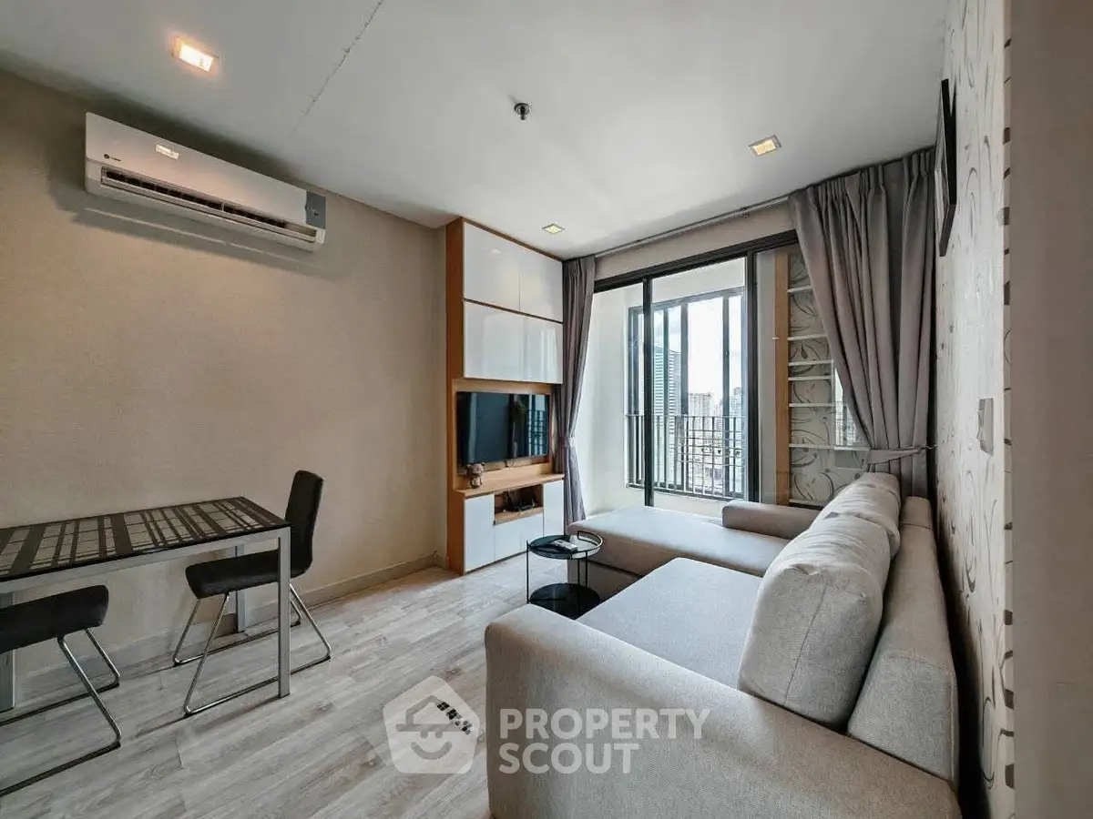 Modern living room with sleek furniture and balcony view in a stylish apartment.