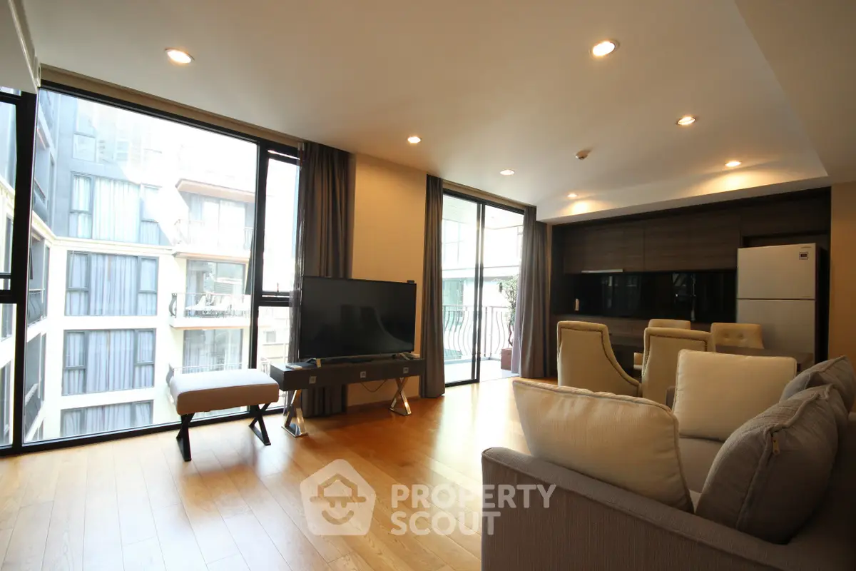 Spacious modern living room with large windows and stylish decor in a luxury apartment.