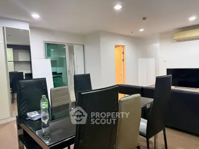 Modern dining area with sleek black chairs and glass table in a stylish apartment.