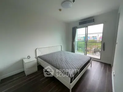 Spacious bedroom with balcony access and modern decor in a bright apartment.