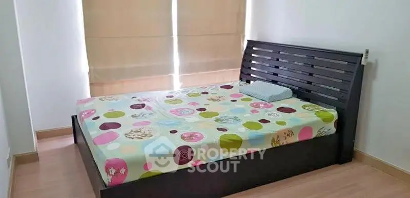 Cozy bedroom with modern bed frame and colorful bedding, perfect for restful nights.