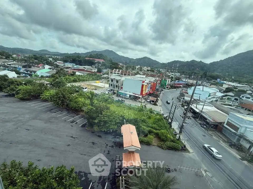 Scenic view of urban landscape with mountains and parking lot, ideal for real estate development.