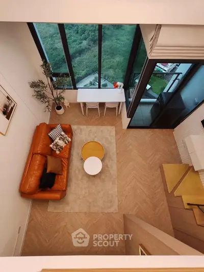 Stunning loft living room with floor-to-ceiling windows and stylish decor, offering breathtaking views.
