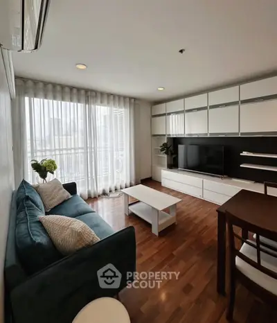 Modern living room with stylish furniture and large windows offering natural light.
